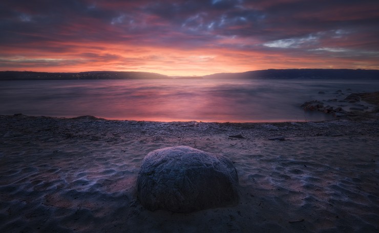 Камень на пляже на закате
