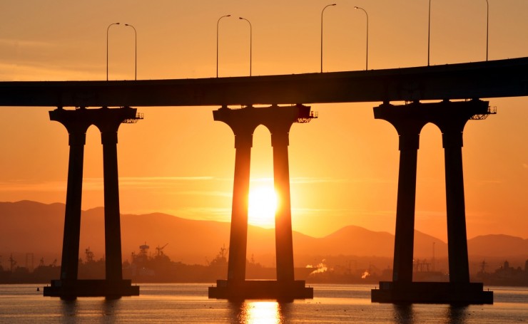 Солнечный закат за опорами моста
