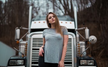 Девушка брюнетка на фоне грузовика