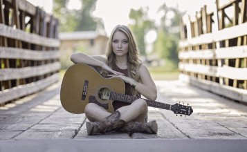 Девушка сидит с гитарой