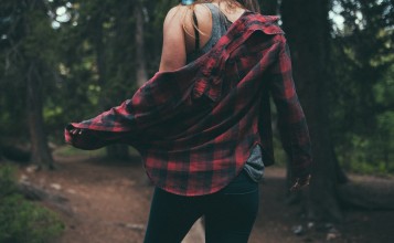 Девушка в рубашке и джинсах в лесу