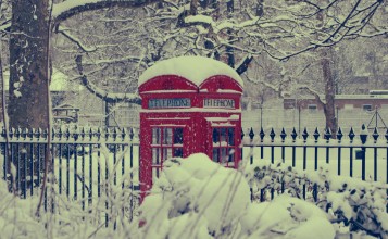 Красная телефонная будка в снегу
