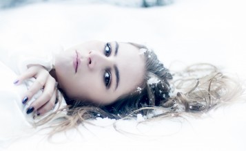 Лицо девушки лежащей на снегу