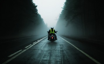 Мотоциклист на мрачной туманной дороге