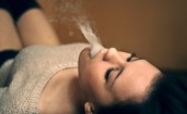 Девушка выпускает дым изо рта