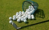 Корзина с рассыпанными мячами для гольфа