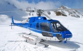 Синий вертолет на снегу среди гор