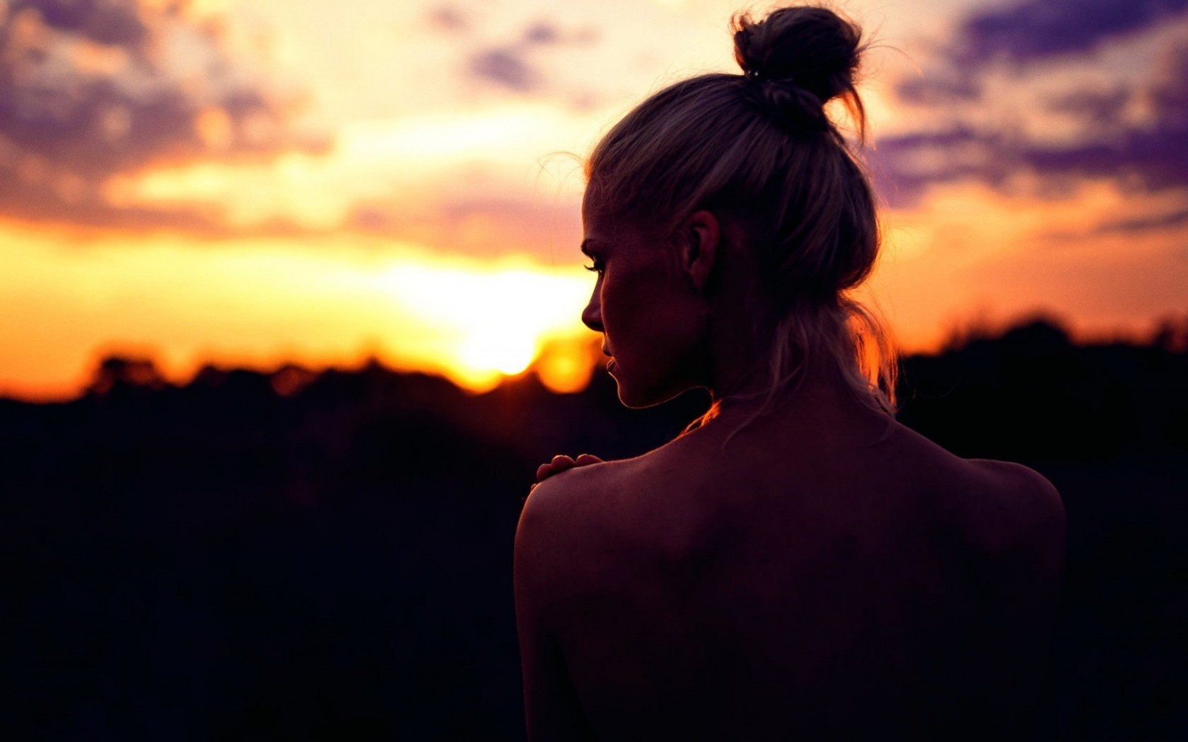 Девушка с красивой грудью на фоне заката