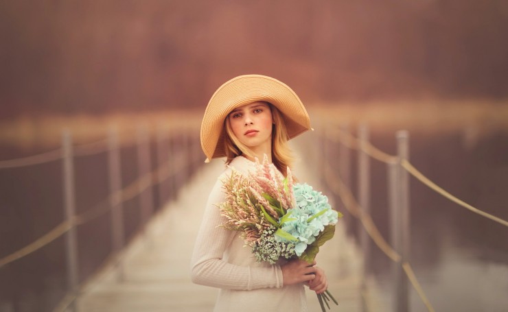 Блондинка в шляпе с букетом цветов