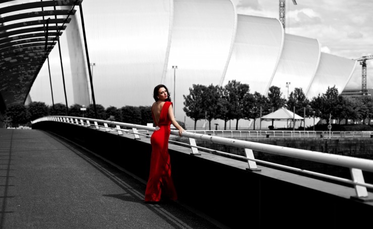 Брюнетка в красном платье в черно-белом городе