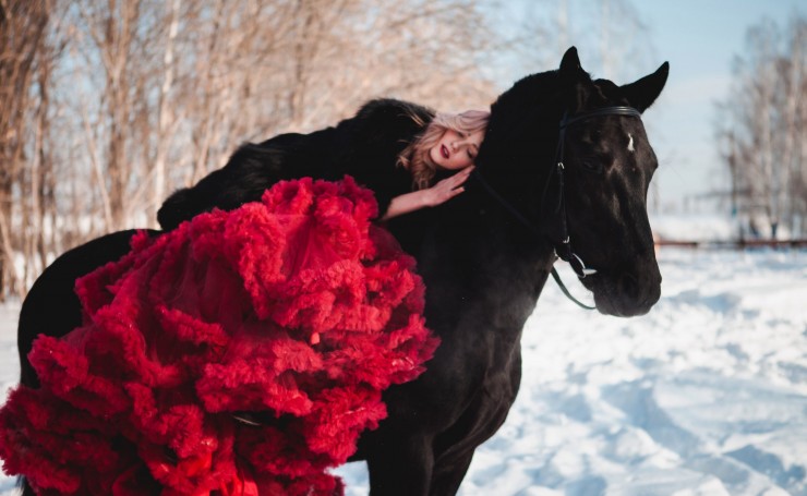Девушка в пышной красной юбке на лошади