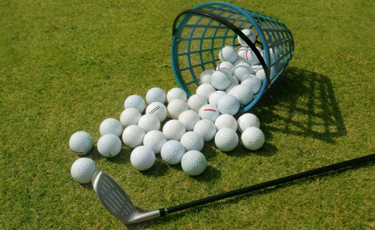 Корзина с рассыпанными мячами для гольфа