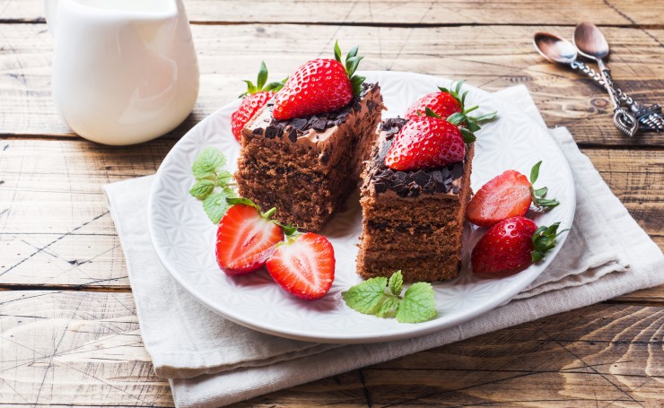 Шоколадные пирожные с ягодами клубники на тарелке