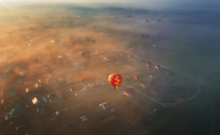 Воздушный шар над маленьким городком, утро, туман