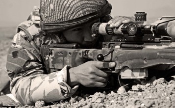 Черно-белый снимок снайпера с винтовкой