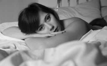 Девушка брюнетка в кровати, черно-белое