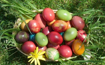Крашеные яйца в корзинке на траве