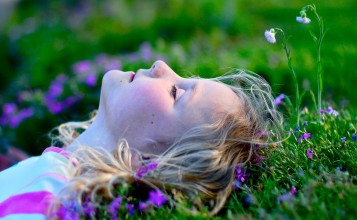Лежащая на траве девочка