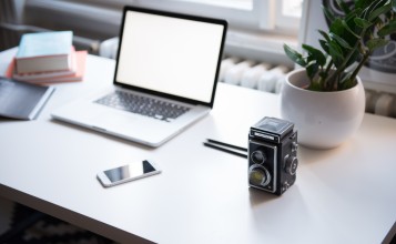 Ноутбук, смартфон и старая камера на столе
