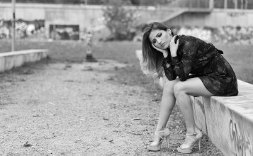 Сидящая девушка в платье и туфлях, черно-белое