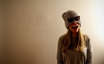 Забавная девушка в шапке с очками