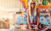 Блондинка со скейтбордом в синих очках
