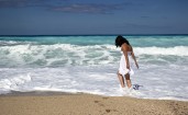 Брюнетка в белом платье на пляже