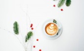 Чашка кофе на белом фоне, ягоды и еловые ветки