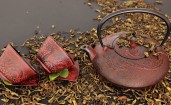 Чайник с чашками и рассыпанные чайные листья