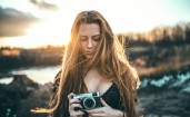 Девушка с фотоаппаратом на фоне заката