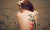 Девушка спиной с татуировкой