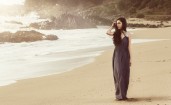 Девушка в длинном темном платье на пляже
