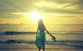 Девушка в платье на пляже на закате