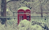 Красная телефонная будка в снегу