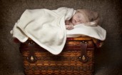 Маленький ребенок спит на чемодане