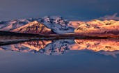 Отражение снежных гор в озере на закате