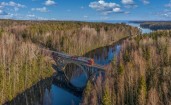 Российский поезд на мосту через реку в лесу