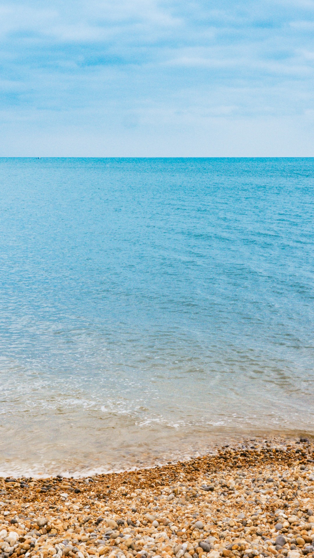 Каменистый пляж и синее море 1080x1920