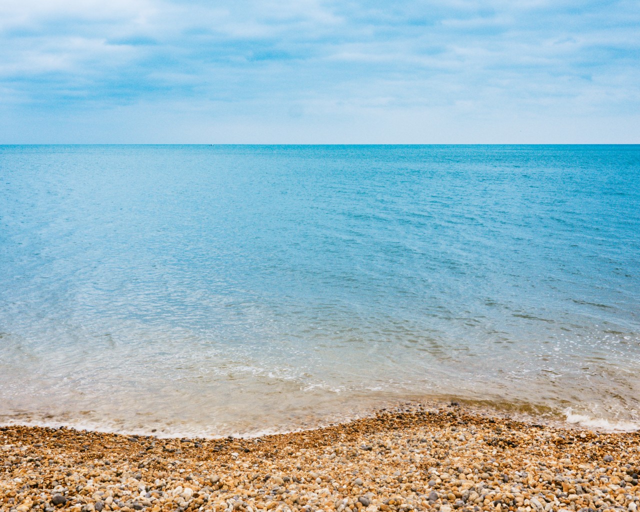 Каменистый пляж и синее море 1280x1024