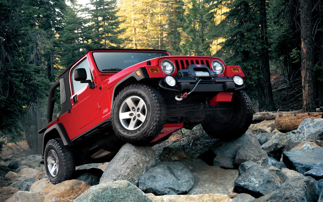 Красный Jeep Wrangler на камнях 1280x800