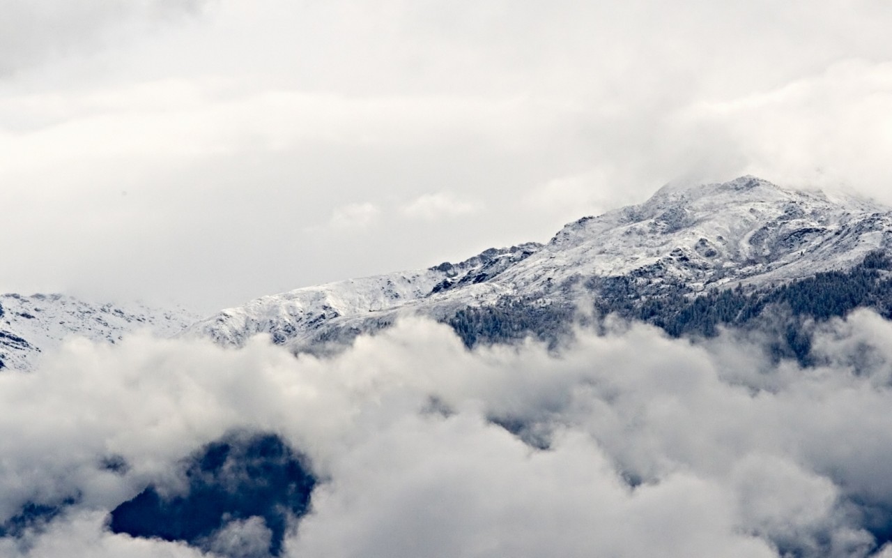 Заснеженные горы над облаками 1280x800