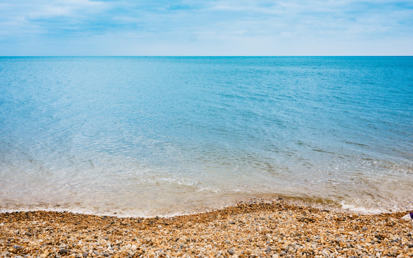 Каменистый пляж и синее море 1440x900