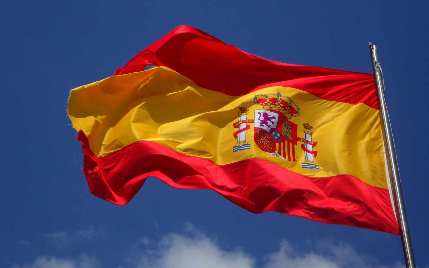 Развевающийся испанский флаг на фоне неба 1440x900
