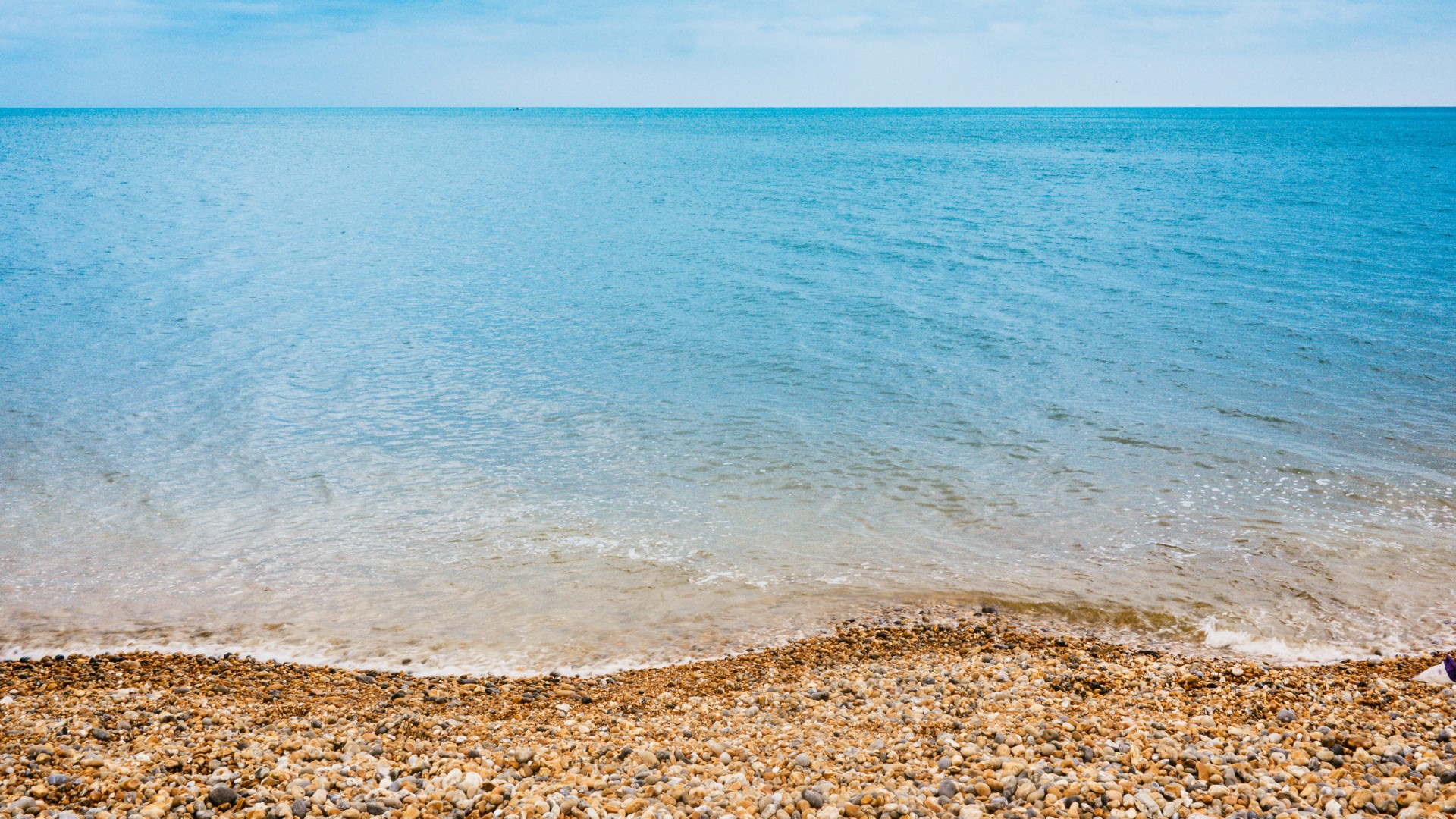Каменистый пляж и синее море 1920x1080