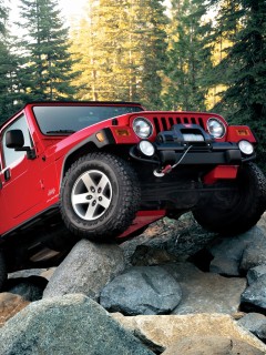 Красный Jeep Wrangler на камнях 240x320