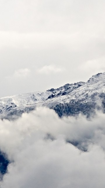 Заснеженные горы над облаками 360x640