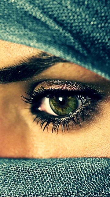 Зеленые глаза девушки в накидке 360x640