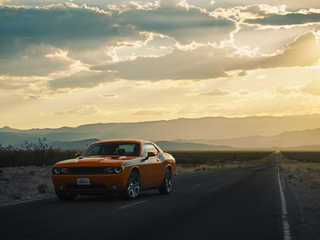 Оранжевый Dodge Challenger на пустынной дороге 640x480