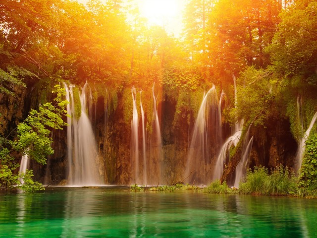 Водопад в лесу под ярким солнцем 640x480