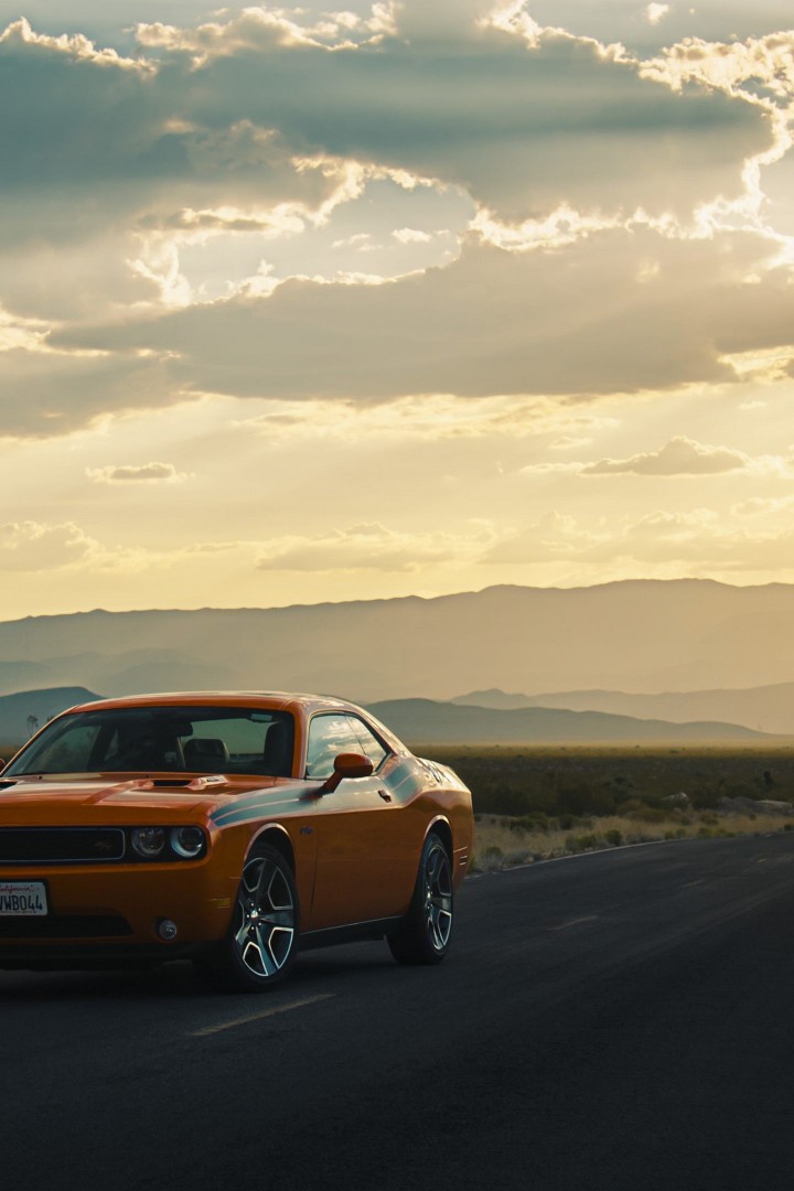 Оранжевый Dodge Challenger на пустынной дороге 720x1080